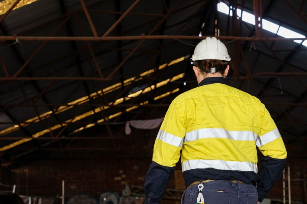 Safetec worker wearing a hardhat inside a large warehouse
